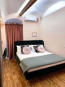 ein Schlafzimmer mit einem Bett mit rosa Kissen darauf in der Unterkunft Rose Apartment in Terlizzi