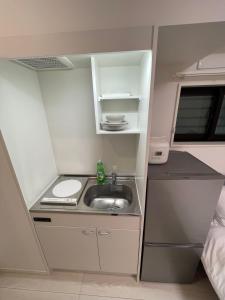 eine kleine Küche mit einem Waschbecken in einem Wohnwagen in der Unterkunft japan house sugamo in Tokio
