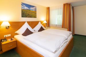 ein Hotelzimmer mit einem großen weißen Bett. in der Unterkunft Hotel Burgfrieden in Beilstein