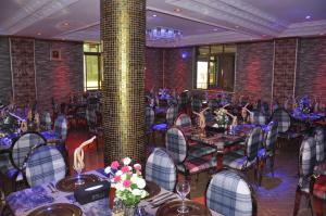 a banquet room with tables and chairs and a column at Biraj International Hotel in Kampala