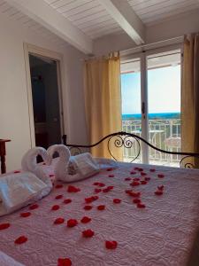 a bedroom with roses on a bed with a window at L'incanto di Nausicaa in Ascea