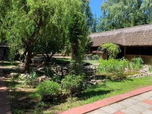 a garden with trees and rocks and a building at Hotel complex Lenivaya Vera in Novaki