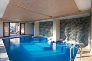 a large swimming pool with blue water in a building at Villa Gradina in Budva