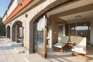 a patio with glass doors and chairs on a building at Villa Gradina in Budva