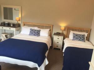 a hotel room with two beds and a mirror at The Coast Yard B & B and Garden Chalets in Chichester