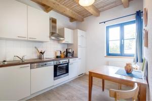 a kitchen with white cabinets and a wooden table at 3-Raum Apartment bis 6 Pers 42 in Rankwitz