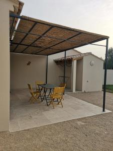 patio ze stołem i krzesłami pod dachem w obiekcie Maison en campagne w Awinionie