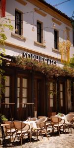 un groupe de tables et de chaises devant un bâtiment dans l'établissement Bohemian Sophie Korce, à Korçë