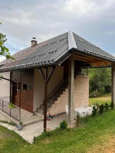 a house with a metal roof and a staircase at Seoska kuća Jela in Nova Varoš