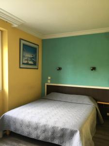 ein Schlafzimmer mit einem Bett in einem Zimmer mit grünen Wänden in der Unterkunft Hotel Val De Saone Lyon Caluire Rillieux in Sathonay-Camp
