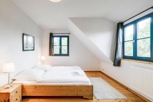 a white bedroom with a bed and two windows at 4-Raum Apartment bis 8 Pers 43 in Rankwitz