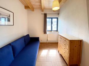 a living room with a blue couch and a window at 4-Raum Apartment bis 8 Pers 43 in Rankwitz