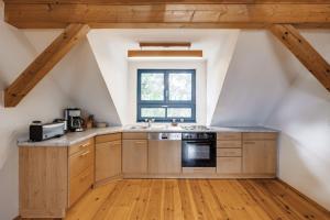 uma cozinha no sótão com armários de madeira e uma janela em 3-Raum Dachgeschoss Apartment 54 em Rankwitz