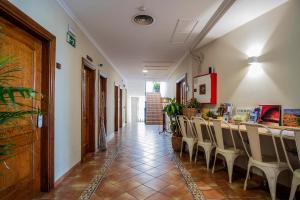 Hotel Doña Matilde في إِستيبونا: ممر مع طاولة وكراسي طويلة
