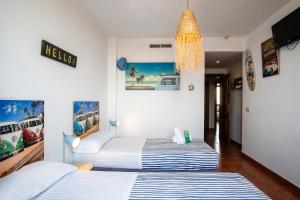 two twin beds in a room with white walls at Hotel Doña Matilde in Estepona