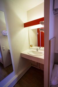 La salle de bains est pourvue d'un lavabo et d'un miroir. dans l'établissement Première Classe Cherbourg - Tourlaville, à Cherbourg en Cotentin