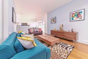 sala de estar con sofá azul y mesa en Interior-Designer Apartment with 2 TERRACES, en Londres