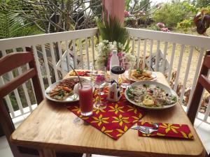 Hôtel La Grillade في موروني: طاولة مع طبقين من المواد الغذائية والمشروبات