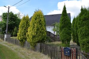 a fence in front of a house with trees at Chata Janov in Janov