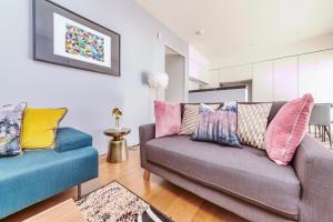 a living room with a couch with colorful pillows at Interior-Designer Apartment with 2 TERRACES in London