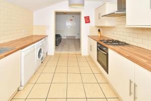 uma cozinha com armários brancos e piso em azulejo em Townhouse @ 115 Walthall Street Crewe em Crewe