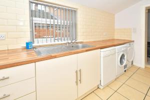 a kitchen with a sink and a washing machine at Townhouse @ 115 Walthall Street Crewe in Crewe