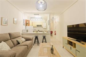 Il comprend un salon avec un canapé et une cuisine. dans l'établissement Apartamento PLAYA12, à Gijón