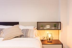 - une chambre avec un lit et une table avec une lampe dans l'établissement Apartamento PLAYA12, à Gijón