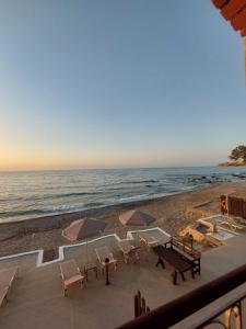 a view of the beach with chairs and umbrellas at Volakas Beachfront Suites in Rethymno Town