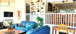 Potters Place Montville في مونتفيل: غرفة معيشة مع أريكة زرقاء وطاولة