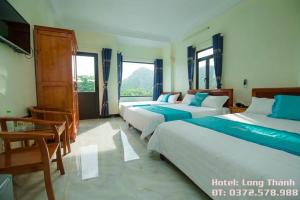 Long Thành Motel في كات با: سريرين في غرفة بها نافذتين
