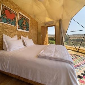 a bedroom with a bed and a large window at Sweet Dome Tafedna in Tafedna