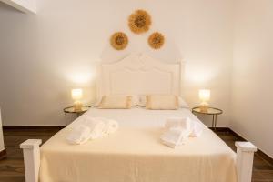 a bedroom with a white bed with two towels on it at Casa da Lota in Manta Rota