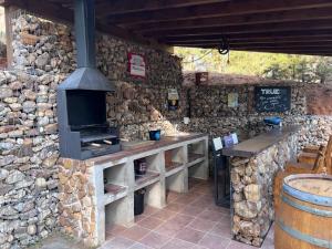 a stone building with a bar with a stove at Stone Garden, Casa en plena naturaleza in Uceda