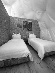 a room with two beds in a tent at Sweet Dome Tafedna in Tafedna