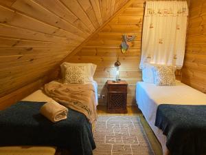 a room with two beds in a log cabin at Chalé 21 in Cortes do Meio