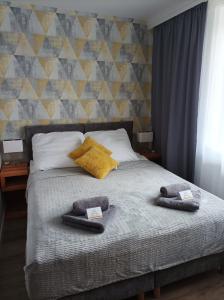 a bed with two towels and two pillows on it at Słoneczna Dziesiątka in Solec-Zdrój