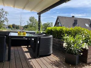 a patio with a table and chairs on a deck at Casalino in Wachtendonk