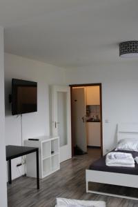 um quarto com uma cama, uma secretária e uma televisão em FeWo Central em Colônia