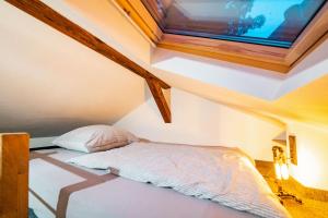 uma pequena cama num quarto com uma clarabóia em Alte Schmiede auf dem Land - Janks 11A em Witzenhausen