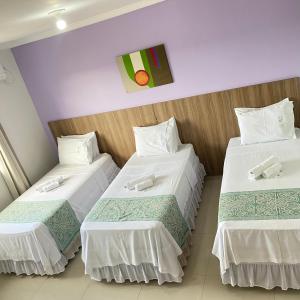 a hotel room with two beds with white sheets at Hotel Rio Verde in Dianópolis
