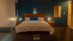 1 dormitorio con 1 cama grande y 1 silla en O Petit Club Africain Dakar en Dakar
