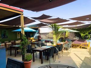 um restaurante ao ar livre com mesas, cadeiras e guarda-sóis em O Petit Club Africain Dakar em Dakar