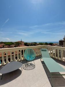 a balcony with a bench and a table and a chair at Re Versiliana Hotel in Marina di Pietrasanta