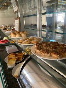 a display case in a bakery with plates of food at Hotel Rio Verde in Dianópolis
