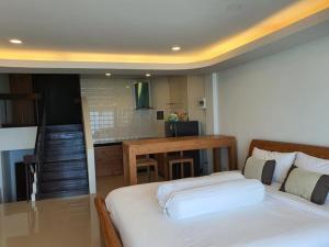 a bedroom with a bed and a kitchen with a table at Grace Seaview บ้านพักส่วนตัว 3 ห้องนอน วิวทะเล หาดพลา in Ban Phala