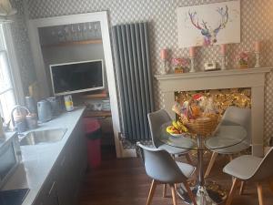 a kitchen with a table and chairs and a fireplace at Georgian city apartment at Thomas Street double bedroom and two single trundle beds in Bath
