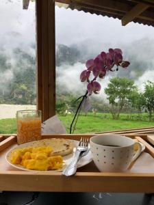 a table with a plate of food and a cup of coffee and a window at MonteLuna Glamping in Choachí