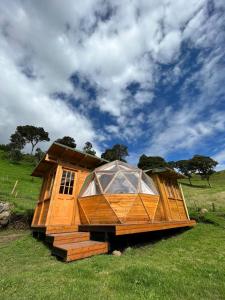 a large wooden house sitting on top of a field at MonteLuna Glamping in Choachí
