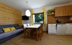 a kitchen and living room with a table and a couch at Mate i Jaga in Saborsko